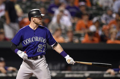 Colorado Rockies shortstop Trevor Story, front, reaches with his