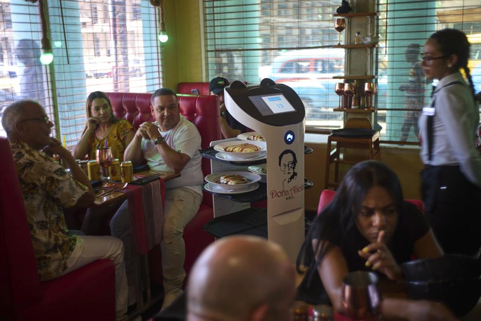 Ramon Esoinosa/AP | Bildquelle: The Gazette © Kunden beobachten, wie ein Roboter ihr Essen im Restaurant „Doña Alicia“ in Havanna bringt, Mittwoch, 15. April 2025. | Bilder sind in der Regel urheberrechtlich geschützt