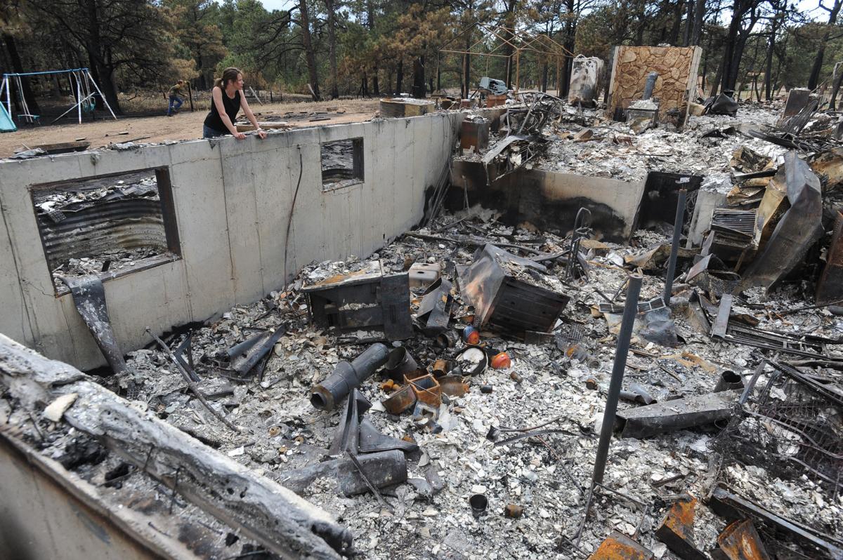 Renee Seay looks into the basement of her father's house and what was her childhood home. Dick Hoffman lost his home in the Black Forest Fire in Colorado . Homeowners that are north of Burgess Rd. and east of Vollmer Rd. in the Black Forest burn area were able to return to their homes today on Tuesday, June 18, 2013.(Jerilee Bennett/The Gazette)
