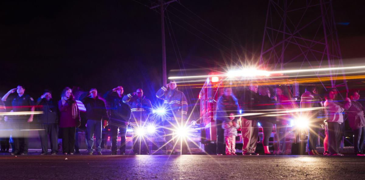 Firefighters salute the procession for El Paso County Sheriff's Deputy Micah Flick outside of the El Paso County Coroners Office Officers on Monday, February 5, 2018. Flick died in a shootout during a stolen car investigation. (Nadav Soroker, The Gazette)