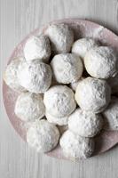 Homemade White Mexican Wedding Cookies On Pink Plate Over White Wooden Background, Top View. Close-u