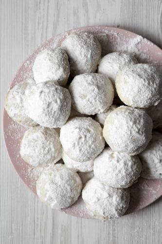Homemade White Mexican Wedding Cookies On Pink Plate Over White Wooden Background, Top View. Close-u