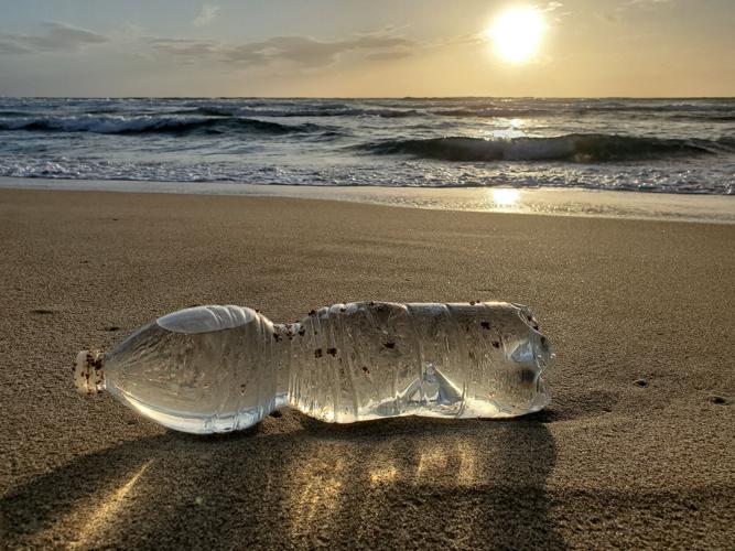 A discarded plastic bottle lies on a beach