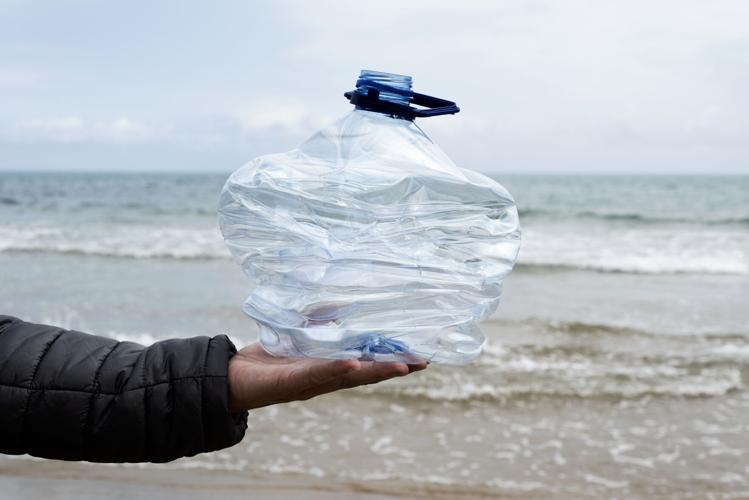 A used plastic bottle is found on the beach