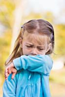 Child coughing or sneezing into arm
