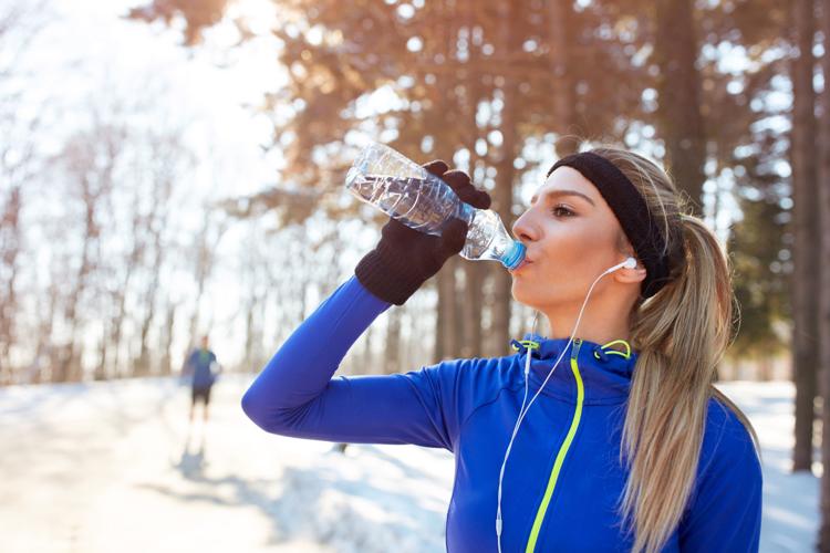 Girl drinks water on winter training outdoor