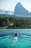 Happy Woman In White Swimsuit Swimming In Luxury Pool Hotel Against Phang Nga Bay Background, Touris
