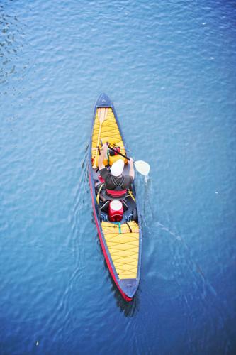 a kayaker in a kayak or canoe paddling down a river - overhead