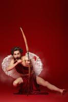 Valentine's Day concept. Full length portrait of the God of love - Cupid aiming with bow and arrow o