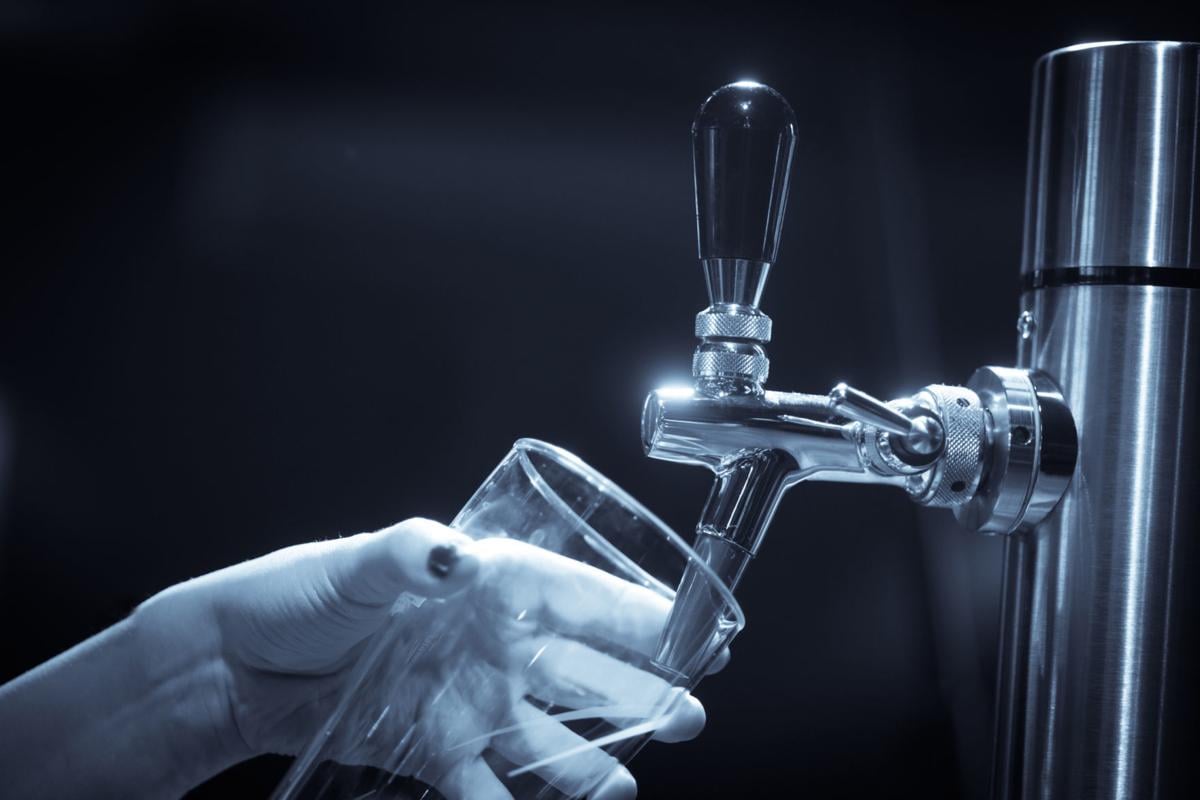 Image of a waiter pouring draught beer into a glass, in a pub or restaurant. (copy)