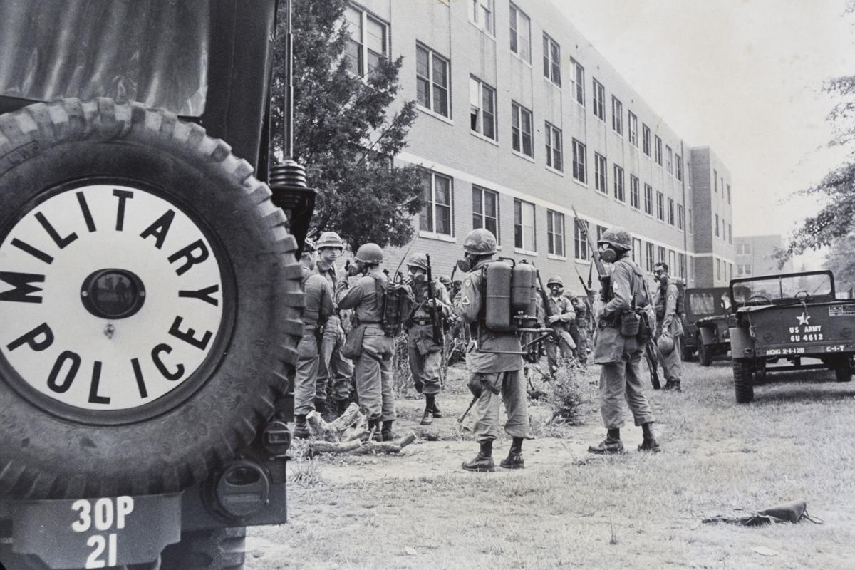 N.C. National Guard soldiers with rifles and gas masks stand outside of the Scott Hall dormitory at N.C. A&T on May 23, 1969. Credit: News & Record