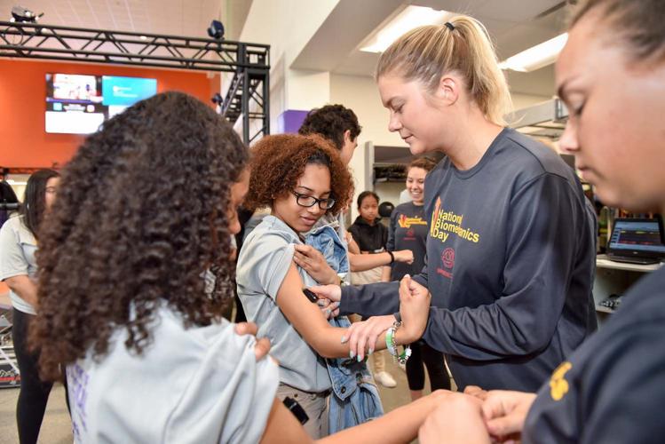 High school students test muscle response during a National Biomechanics Day celebration