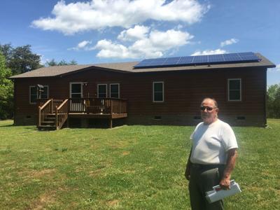 Ronnie Williams stands in front of his soon-to-be solar-powered home.