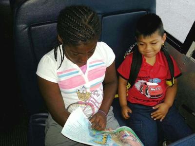 Students read while riding bus