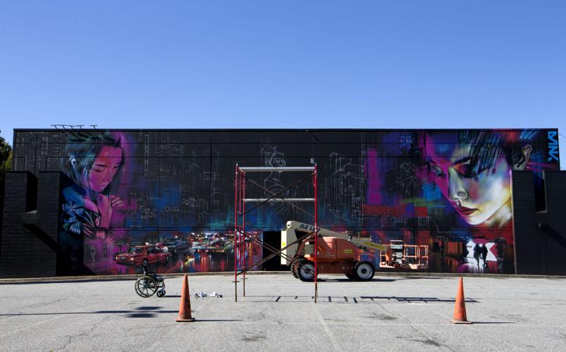UK based artist Dan Kitchener paints a large mural on the Red Ci