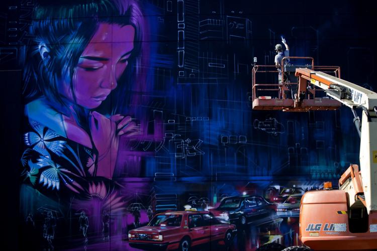 UK based artist Dan Kitchener paints a large mural on the Red Ci