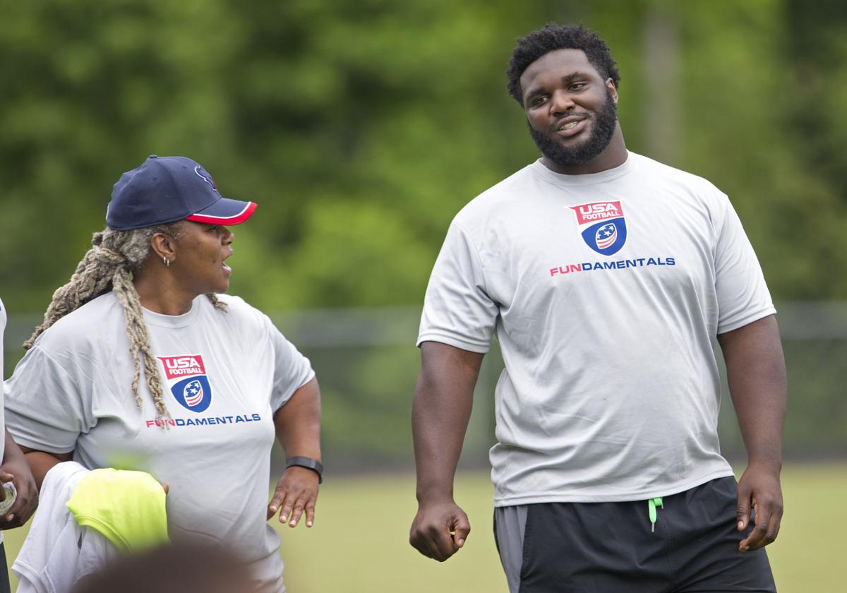   Felicia Reader walks with her son, D.J. Reader during a youth football camp in Greensboro in 2016. Joseph Rodriguez, News & Record 