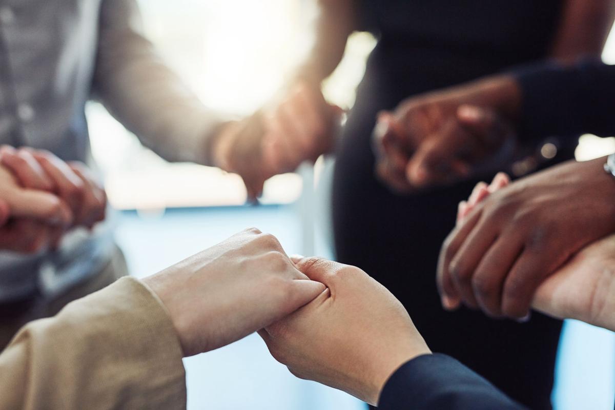 Cropped shot of a people standing together and holding hands