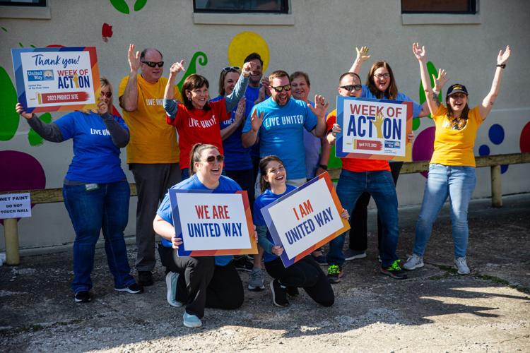 Volunteers paint mural on front of Facing Hunger Foodbank during United