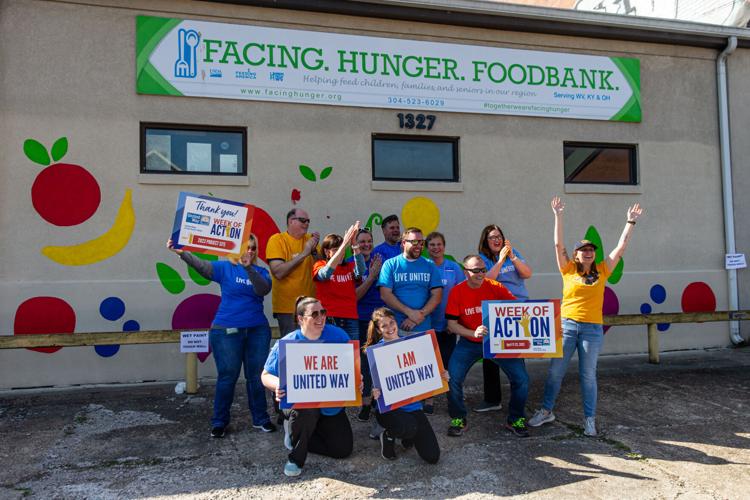 Volunteers paint mural on front of Facing Hunger Foodbank during United