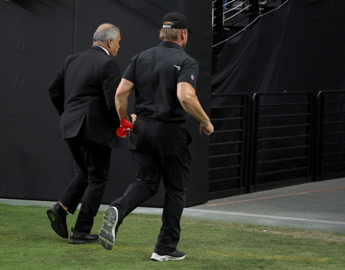 Las Vegas Raiders director of team security Bob Stiriti, left, and Raiders head coach Jon Gruden run off the field after the team's 20-9 loss to the Chicago Bears at Allegiant Stadium on Oct. 10, 2021, in Las Vegas.