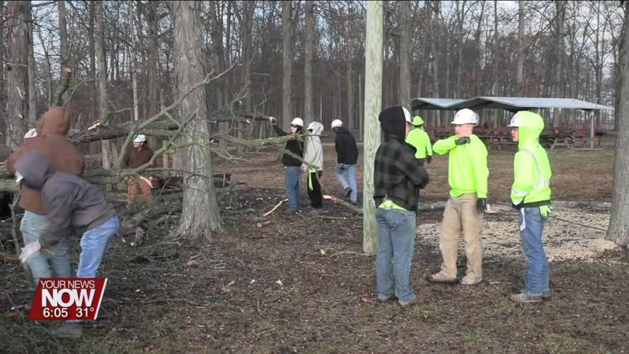 Students from Apollo Career Center take part in cutting down a problematic tree at Camp Robin Rogers