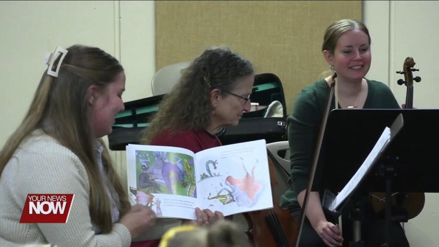 Young children learn about and hear music from string instruments at Symphony Storytime