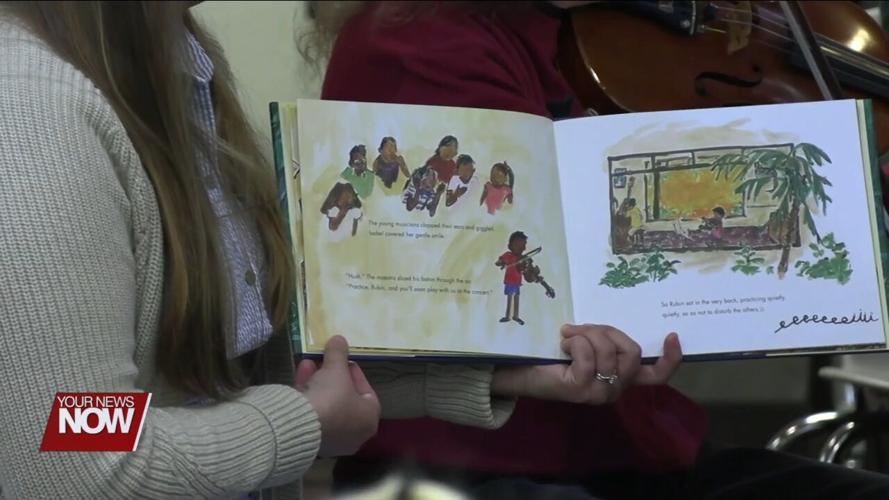 Young children learn about and hear music from string instruments at Symphony Storytime