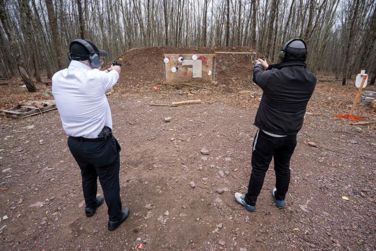 Chaim Nieman, left, and Zalmy Cohen stand next to each other while shooting pistols at a private gun range on Sunday, March 22, 2026, in Pennsylvania.