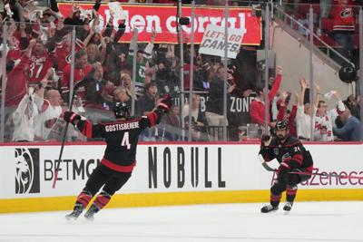 Carolina Hurricanes right wing Seth Jarvis (24) celebrates scoring with defenseman Shayne Gostisbehere (4) in overtime against the Vegas Golden Knights.