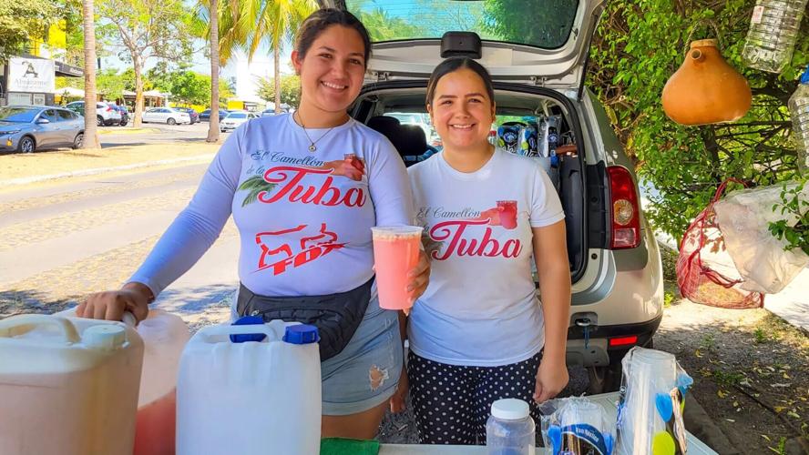 Sisters Amairani and Karla Bejarano, right, sell tuba on a street in Colima, Mexico.