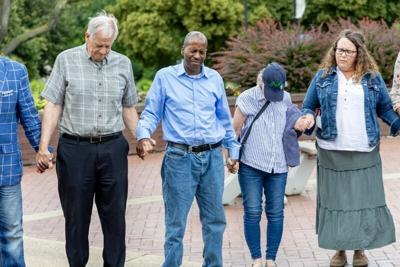 Rally attendees hold hands in prayer during the annual Prayer for Peace Rally held at the Jon Hunt Plaza in front of the Morris Performing Arts Center Sunday, June 14, 2026. Becky Malewitz/Special To The Tribune