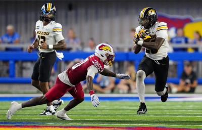 Missouri running back Jamal Roberts carries the ball as Kansas cornerback Elijah Cannon looks to make a tackle during the second half at David Booth Kansas Memorial Stadium on Friday, Sept. 11, 2026, in Lawrence, Kansas.
