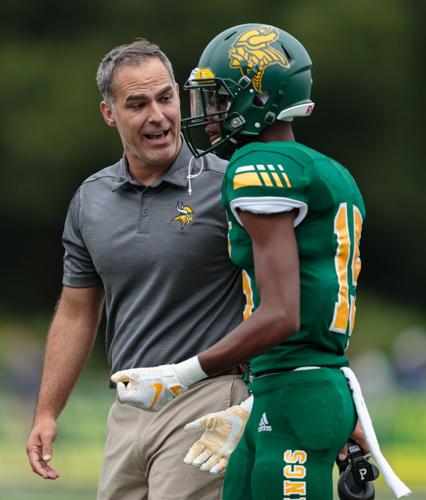 Central Cabarrus's head coach Kenneth McClamrock talks with Jason Rogers-Freeman (15) on Saturday evening at Central Cabarrus High School. After trailing 20-0 at halftime to the Vikings, the Ragin' Bulls made an incredible comeback to win 27-20.
