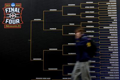 A person walks past a large bracket during the practice day of the 2026 NCAA Men's Basketball Tournament at Lucas Oil Stadium on April 3, 2026, in Indianapolis.