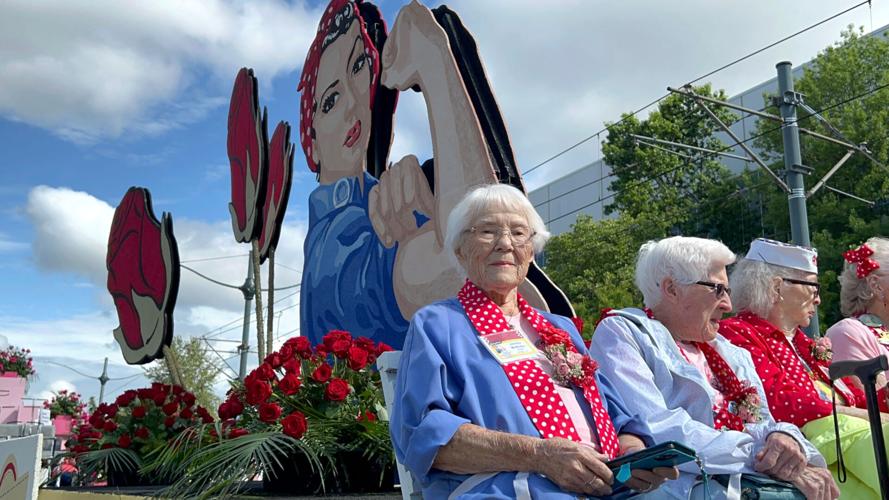 Jennifer McMullen (left) rides on a float in 2023 marking the contributions of women like her, whose work during World War II helped the Allied war effort.
