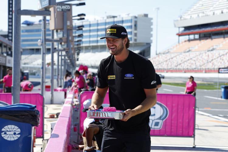 Todd Gilliland prepares to paint pit road wall at the annual event at Charlotte Motor Speedway to preview the upcoming Blue Cross NC 300