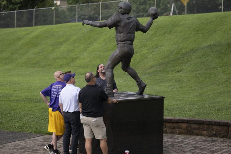 From left, West Chester University football alumni Tom Weaver, Mike Esposito, Bob Campbell, Mike Hudson and Dean DiPasquale take a close look a statue honoring their former teammate Michael Horrocks on Aug. 17, 2026, in Chester County, Pennsylvania.