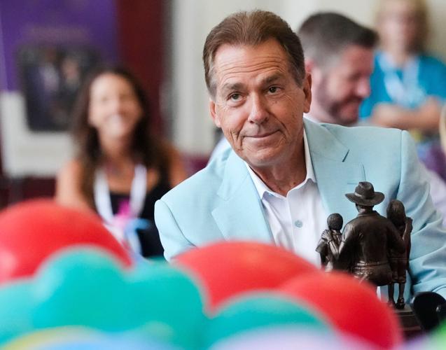 Aug. 4, 2026; Tuscaloosa, AL, USA;  Nick Saban smiles as hold the Lifetime Achievement Award he and Terry Saban are about to present to Stephanie Bryan, Chair and CEO of the Poarch Band of Creek Indians, at the North Zone in Bryant-Denny Stadium for the an
