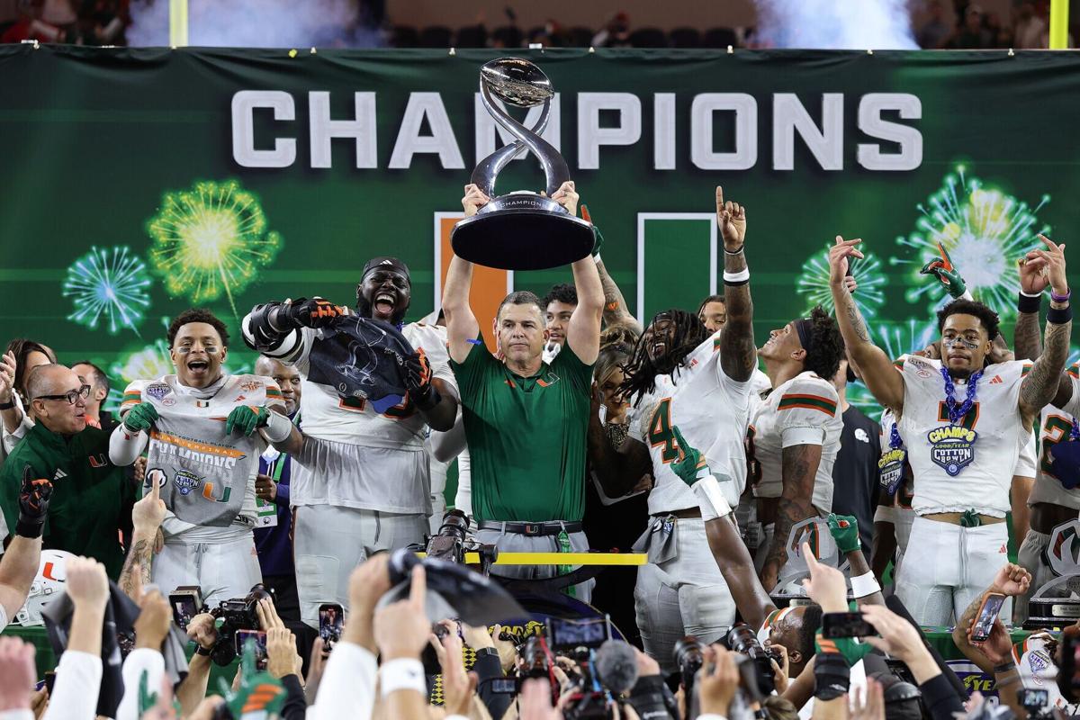 Miami head coach Mario Cristobal hoists the Field Scovell trophy after beating Ohio State, 24-14, in a College Football Playoff quarterfinal at the 90th Goodyear Cotton Bowl Classic at AT&T Stadium on Wednesday, Dec. 31, 2025, in Arlington, Texas.