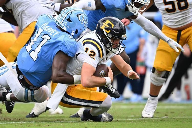 Sep 12, 2026; Chapel Hill, North Carolina, USA; ETSU Buccaneers quarterback Mason Mims (12) is sacked by North Carolina Tar Heels defensive end Jaylen Harvey (11) in the second quarter at Kenan Stadium. Mandatory Credit: Bob Donnan-Imagn Images