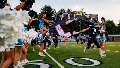 Enka’s Ayden Ramsey (2) leads the Jets onto the field before a football game against North Henderson at Enka High School on Aug. 21, 2026.
