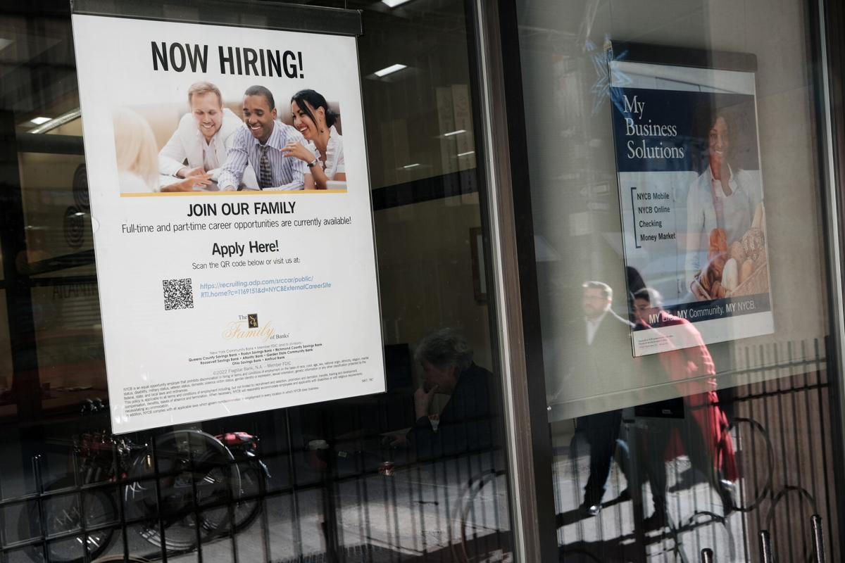 A' now hiring' sign is displayed in a window of a store in Manhattan on Dec. 2, 2022, in New York City.