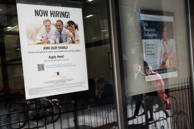 A' now hiring' sign is displayed in a window of a store in Manhattan on Dec. 2, 2022, in New York City.