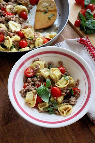 A quick one-pan dinner pairs sweet Italian sausage with cheese tortellini and grape tomatoes.