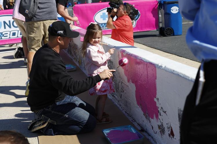 Ryan Preece and his daughter paint pit wall during Charlotte Motor Speedway's Paint Pit Wall Pink event on Tuesday