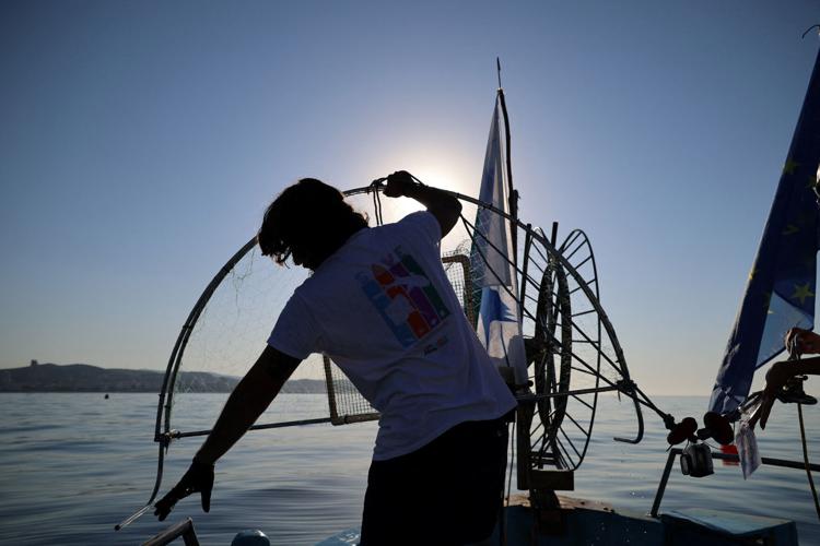 Ikaros Savva, a marine biologist at the Marine and Environmental Research Lab, checks a trap for lionfish near the coastal city of Limassol
