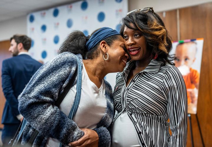 Nicole Coutrier-Phillips, left, of Inkster, nuzzles her pregnant daughter Nyah Phillips, of Inkster, after she gave a speech about the challenges she saw her mother go through to raise her and the excitement for being a part of the Rx Kids program as it ro