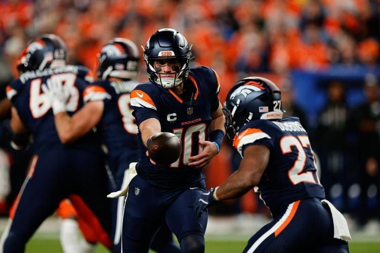 Week 4: Denver Broncos quarterback Bo Nix (10) hands the ball off to running back J.K. Dobbins during the "Monday Night Football" ga,e against the Cincinnati Bengals at Empower Field at Mile High. The Broncos wore their "Midnight Navy" uniforms for the ...