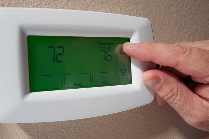 Changing the temperature on a digital thermostat.